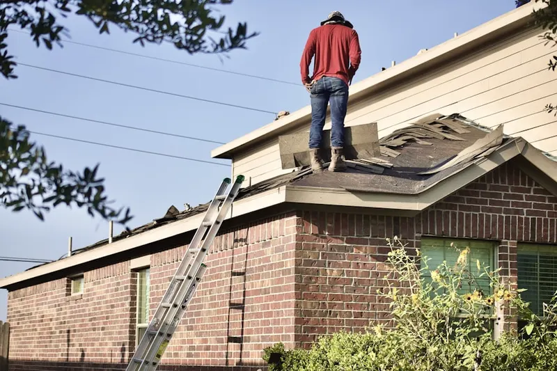 Professional roofer working on a residential roof in Martins Additions
